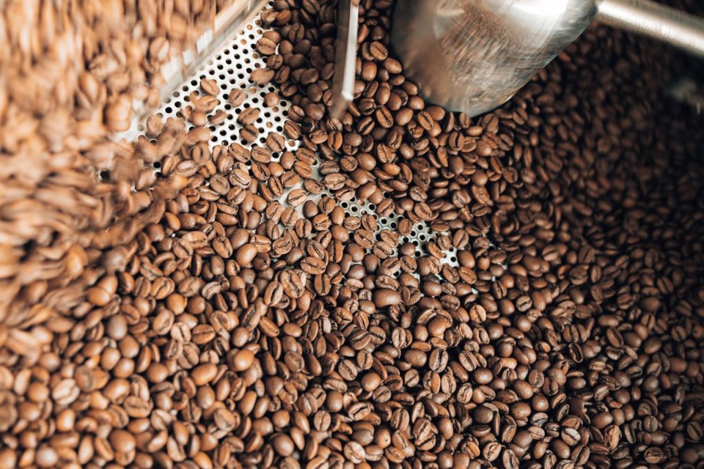 High-quality image showing freshly roasted coffee beans inside a coffee roaster.